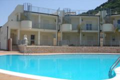 Sea-view apartments with garden/roofterrace and communal pool. 